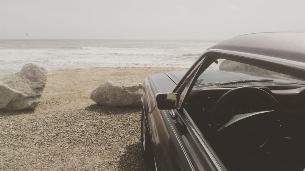 renting a car in Corfu- car overlooking beach