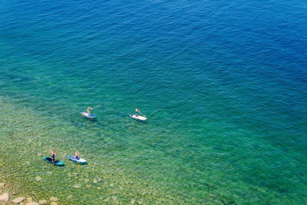 Private Sailing Boat Charter With Paddleboarding in Malta, blue and clear water, sandy sea floor, paddleboarding, people, Malta
