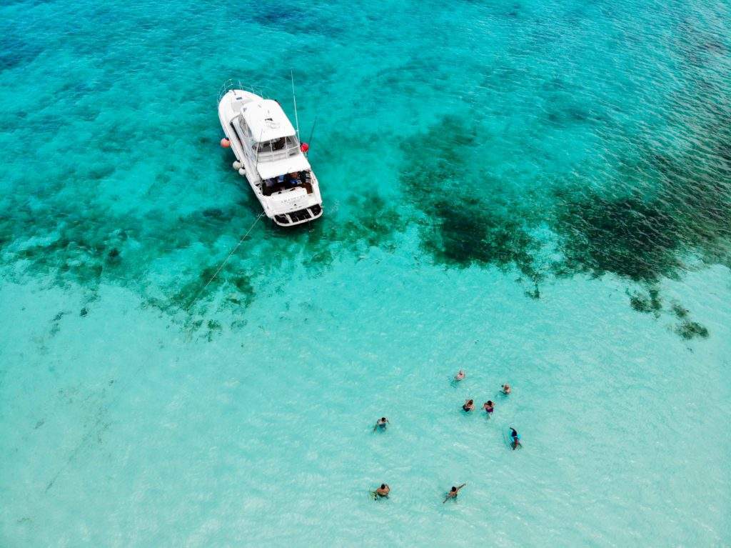 The Best Private Malta Boat Tour From Valletta, bright blue water, boat, swimmers, Malta