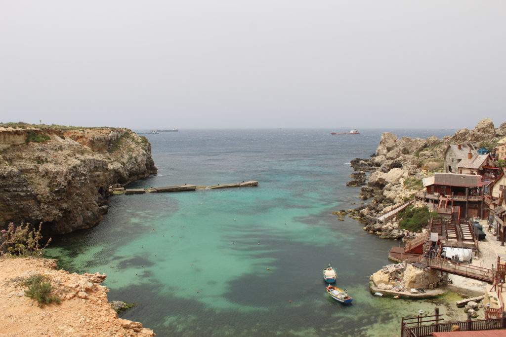 visiting Popeye Village from Valletta, Malta- blue water, sand cliff, Popeye wood village