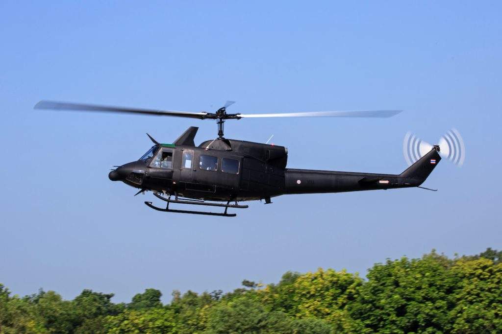Helicopter Tours Italy to Mount Etna- blue sky, black helicopter, green trees