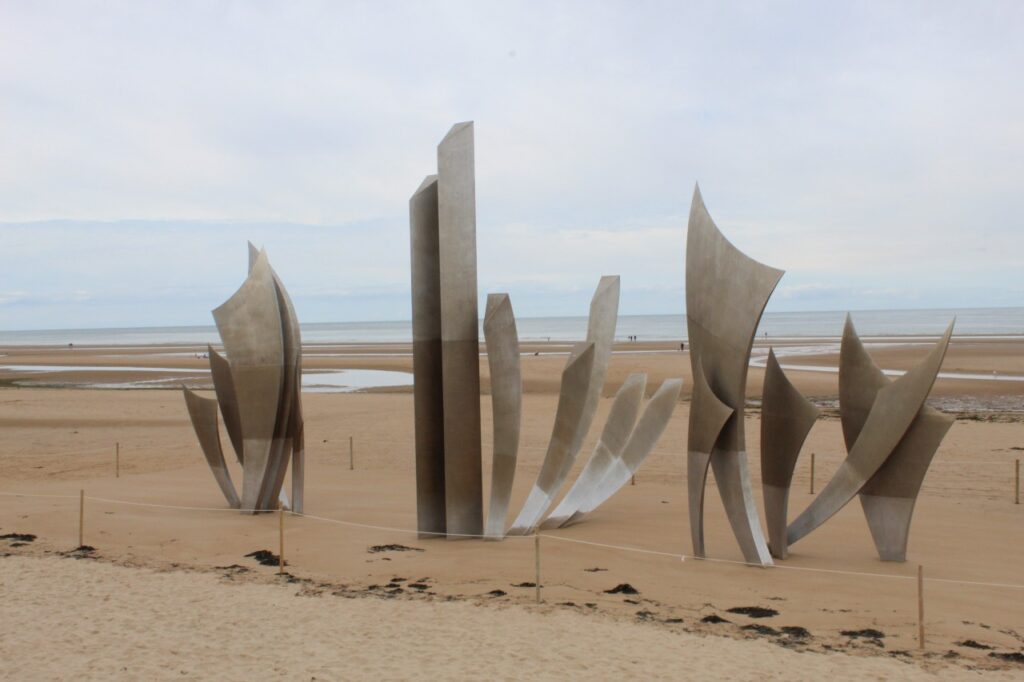 The silver wave like spikes stand up on the yellow sands of Normandy as a tribute to the lives lost during the landings