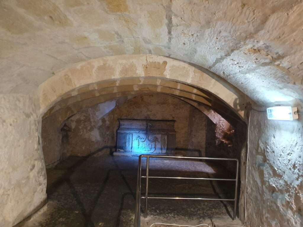Top Malta Private Tours, St. Agatha's catacombs. Steps to enter the Catacombs in Malta, dark and limestone coloured stones near metal steps