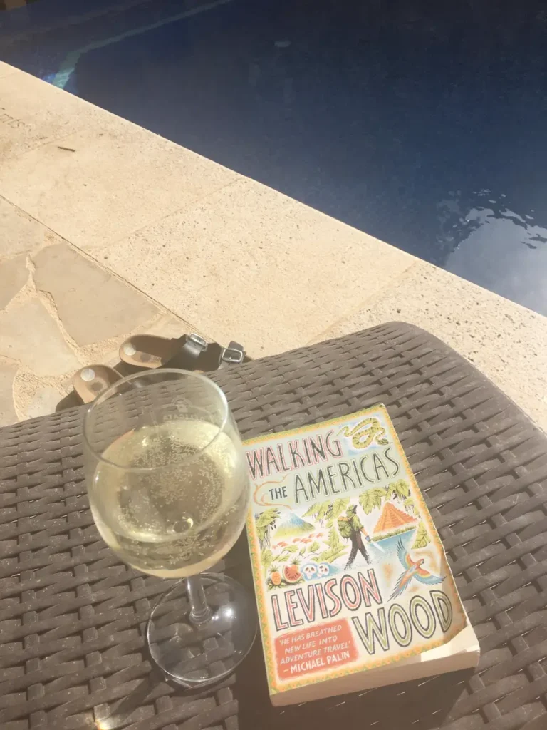 where to stay in Malta without a car- hotel pool, marble edge, white wine in glass, book