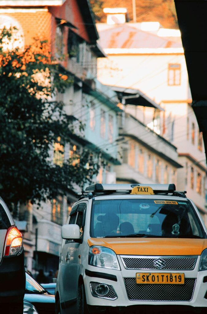 Yellow and white taxi cruising through the charming streets of Greece, ready to transport passengers amidst the Mediterranean vibes and scenic coastal views