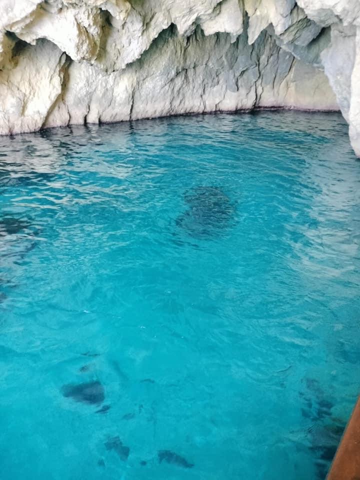 bright blue waters underneath the white sea caves in Corfu