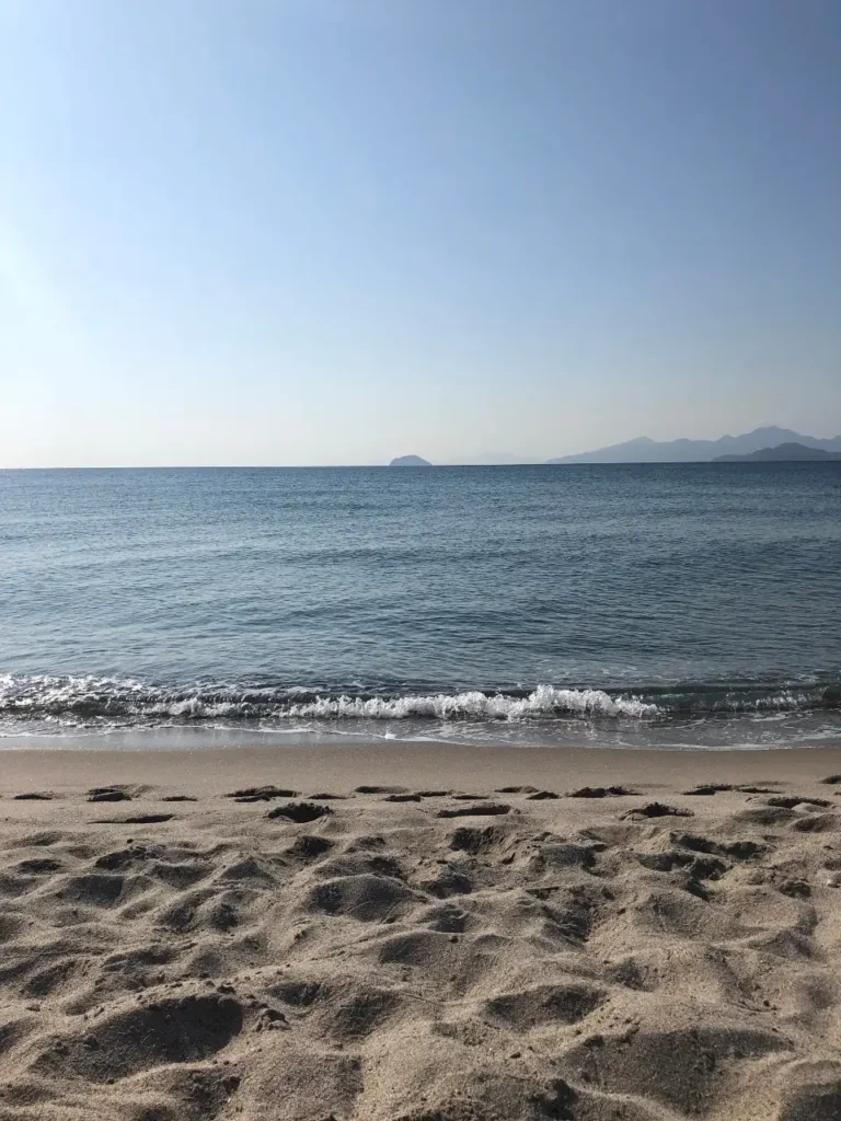 sandy beach with blue gentle waves in the distance are what you can find all over Kos Island in Greece. The calm conditions make it a great destination for all, especially if you love to swim.